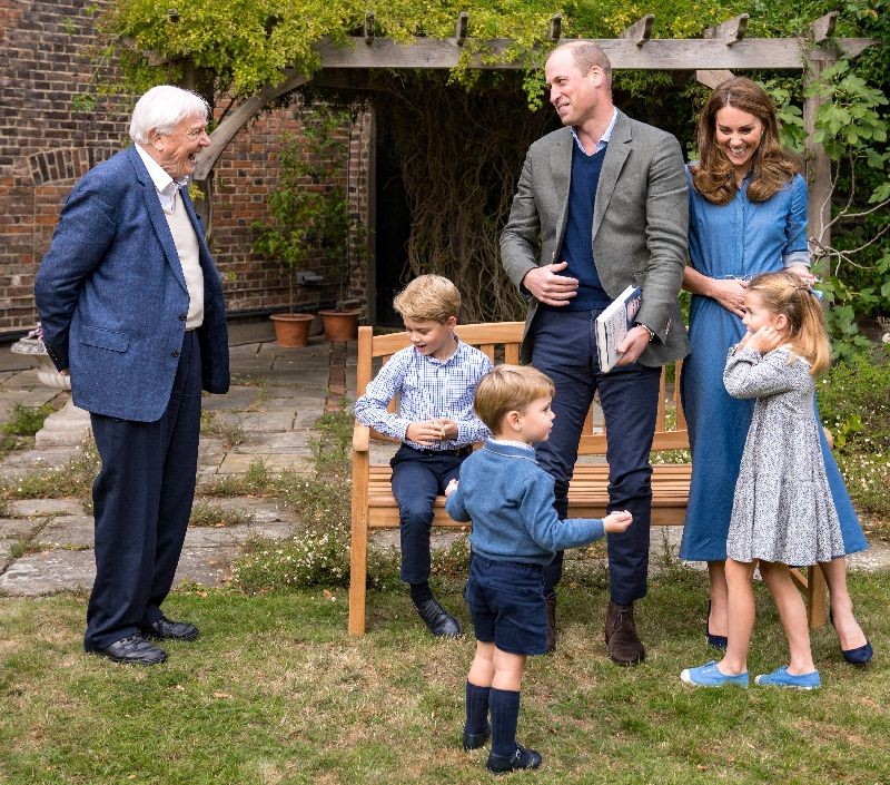 A handout photo released by Britain's Prince William and Cathrine, Duchess of Cambridge, Prince George (seated), Princess Charlotte and Prince Louis with David Attenborough after Prince William and David Attenborough attended an outdoor screening of the upcoming Attenborough's feature film, in the gardens of Kensington Palace, in London, Britain, September 24, 2020. Picture taken September 24, 2020. Duke and Duchess of Cambridge/Kensington Palace/Handout via REUTERS